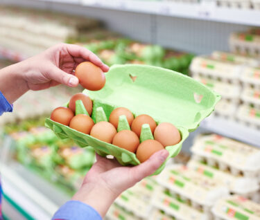 Mujer comprando huevos en el supermercado